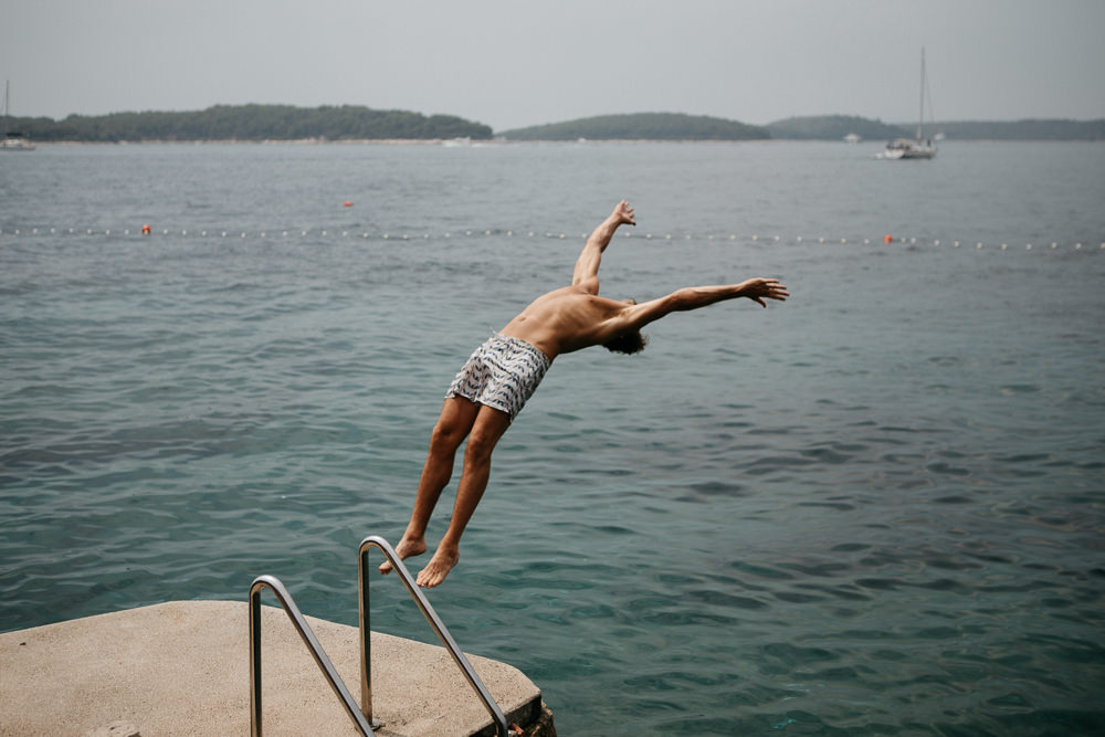 groomsmen diving backflip in Hvar Croatia on the wedding day