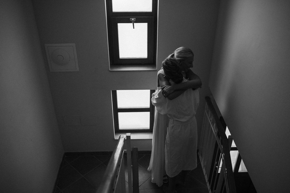 bride and bridesmaid sister hugging when getting ready on her wedding day