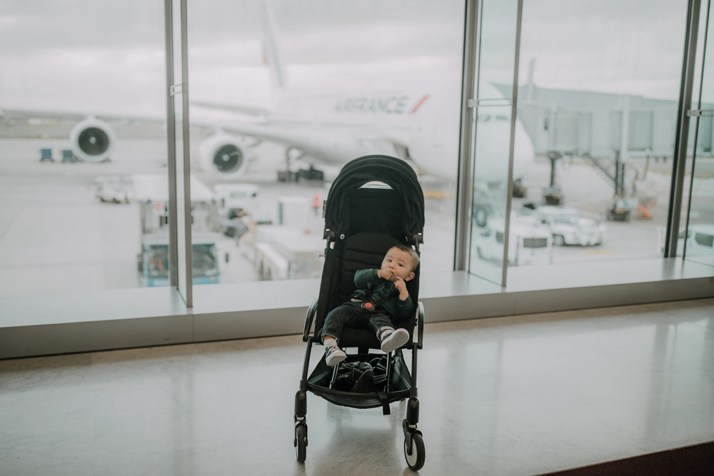 Baby in front of Air France A380 plane in a Babyzen Yoyo pram